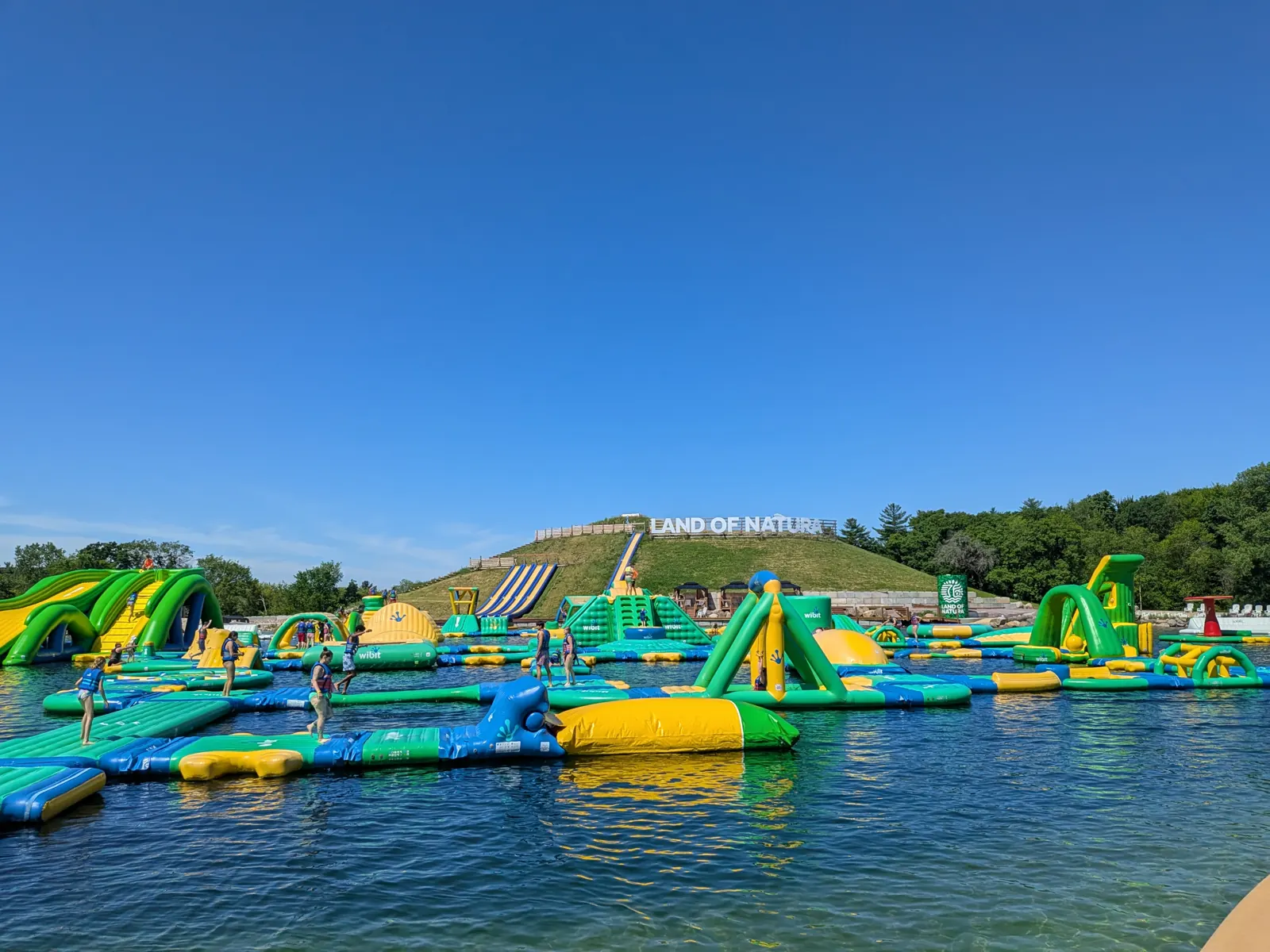 The floating inflatable waterpark on the clear lake at Land of Natura in Wisconsin Dells