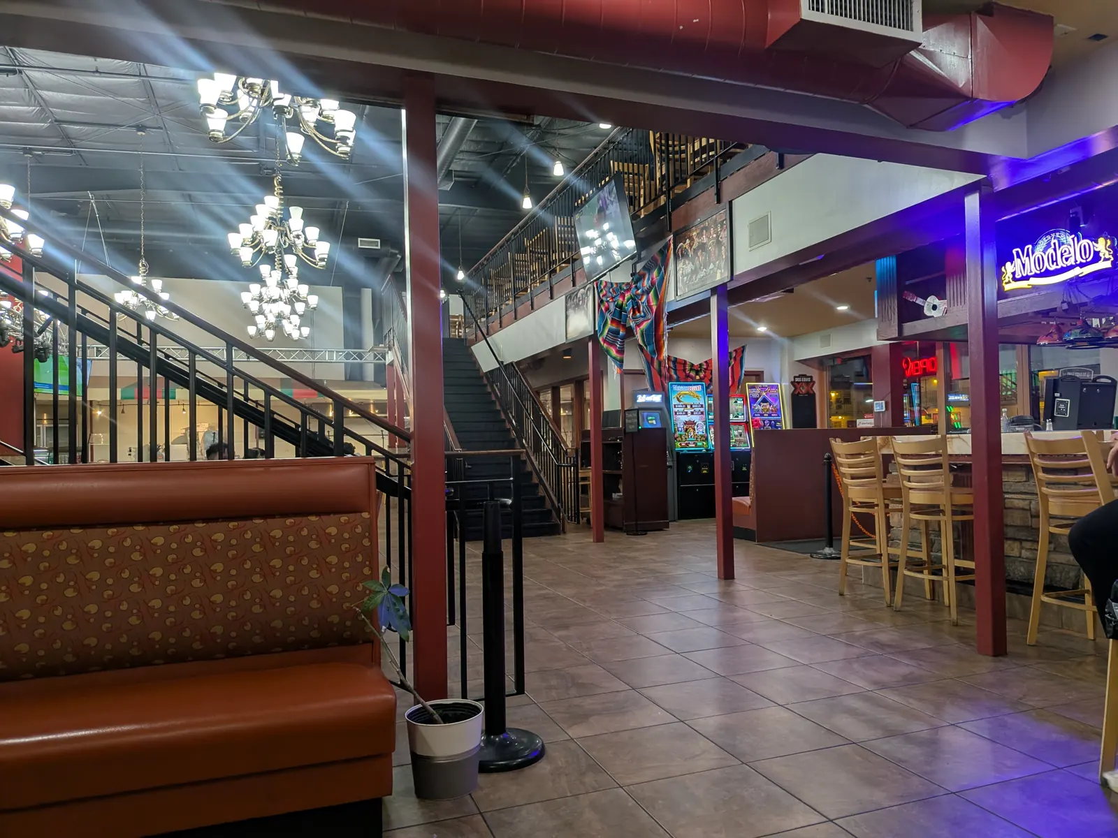The bar area at MarAzul, with neon signs and a staircase to the upper level