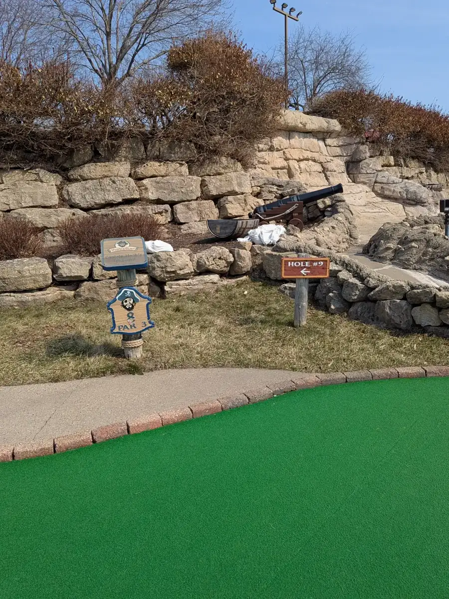 A green running past a rock wall at Pirate's Cove