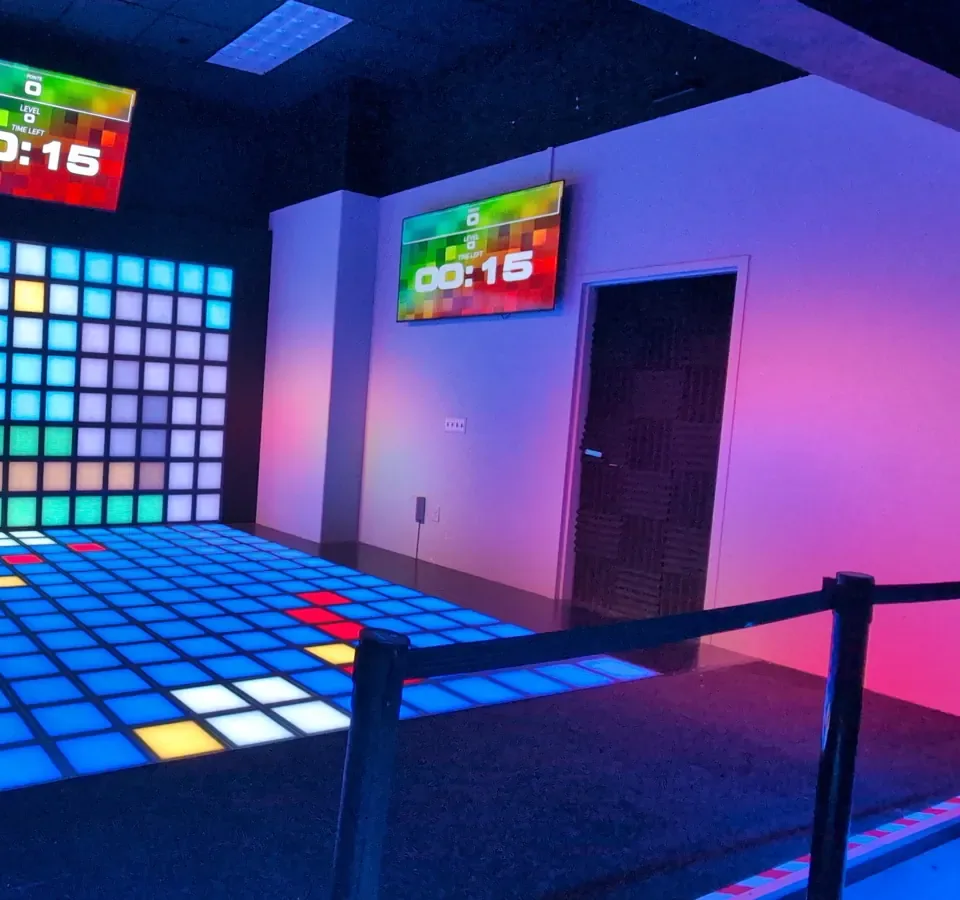 A player racing across the light-up floor at Atomic Rush
