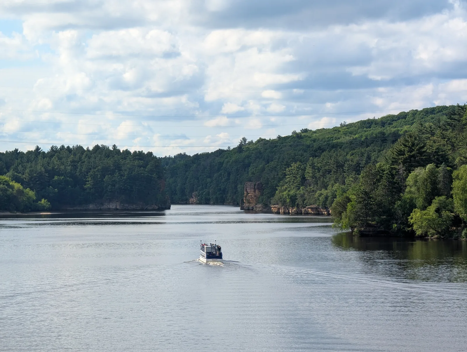 A tour boat on the wide Wisconsin River below the dam