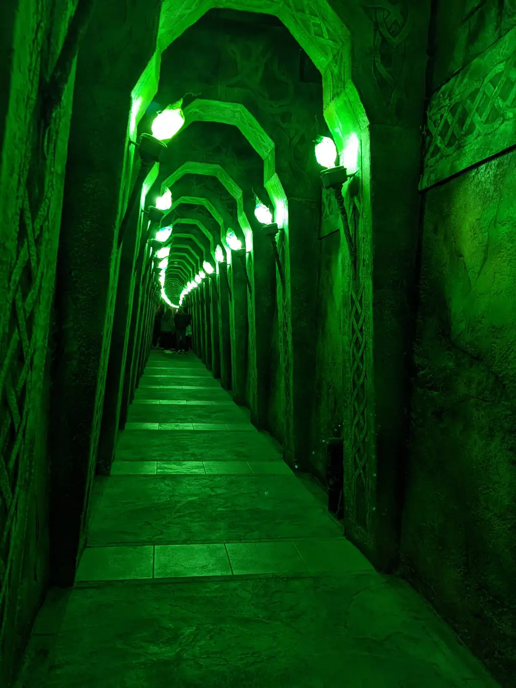 A glowing green corridor of arches inside Wizard Quest in Wisconsin Dells